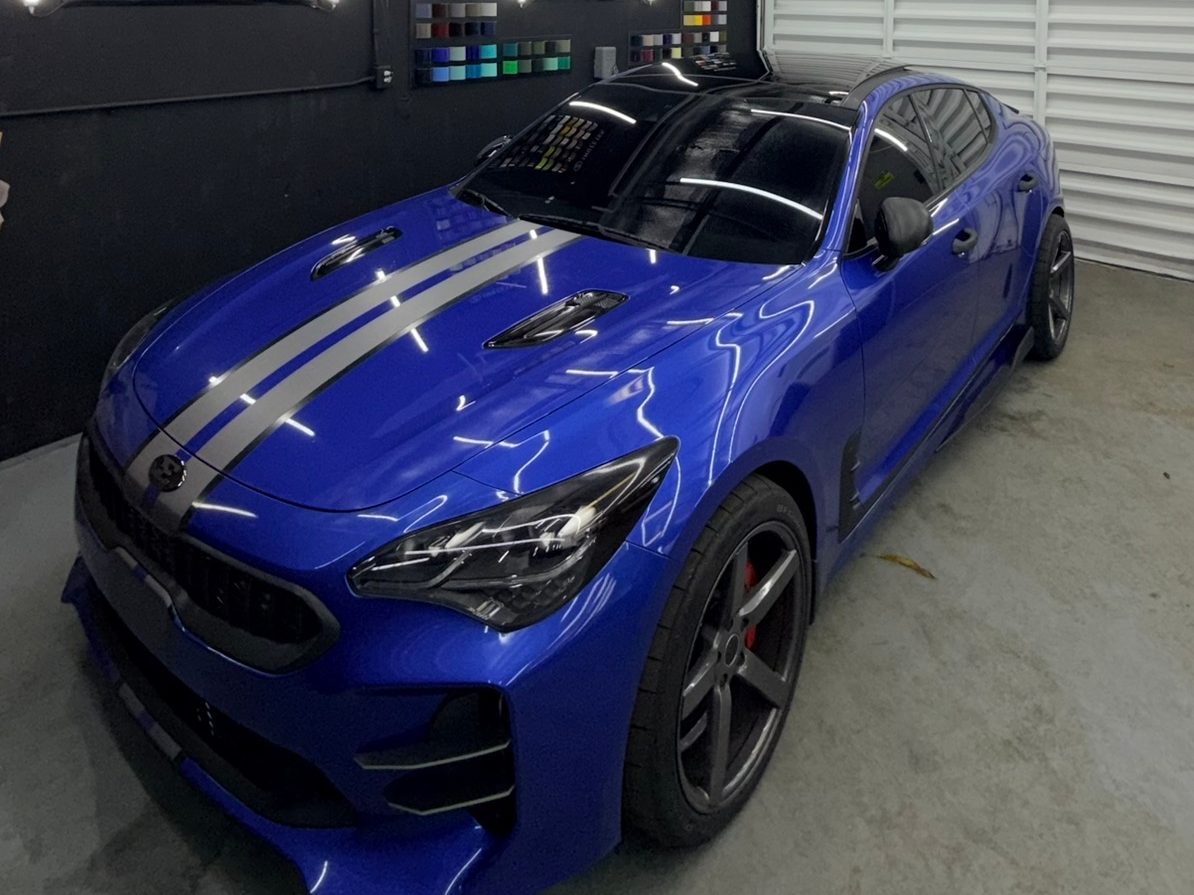 Blue Kia Stinger with silver racing stripes
