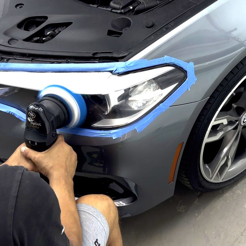 Headlight being polished by machine