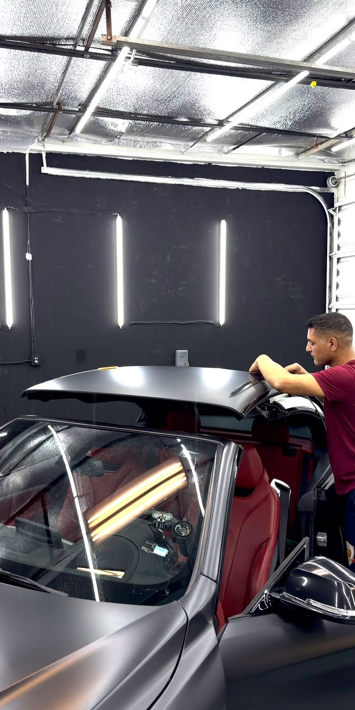 Installer at work on a satin grey convertible