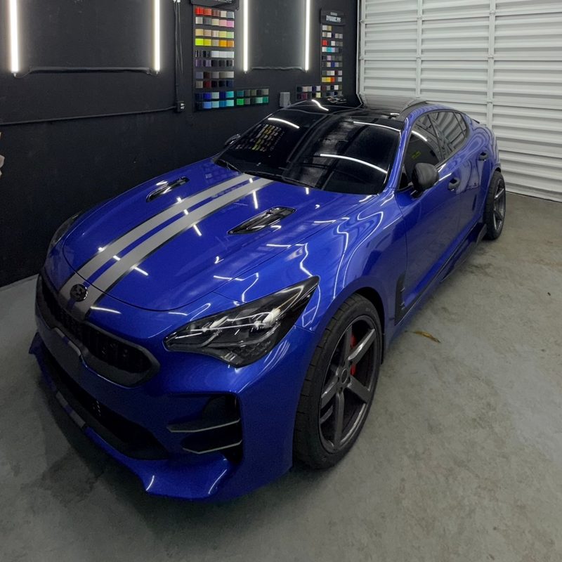 Blue Kia Stinger with silver racing stripes