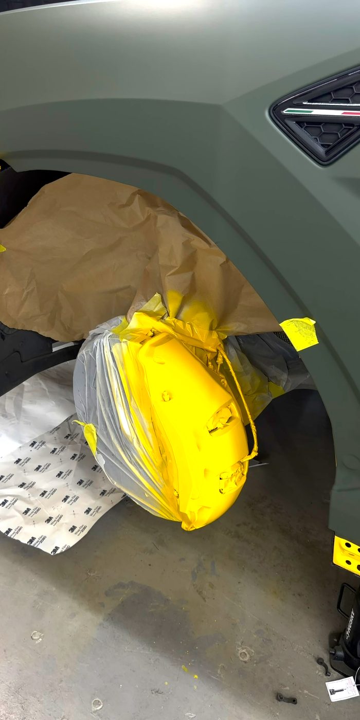 Lamborghini Urus brake caliper freshly painted yellow, rotor masked off