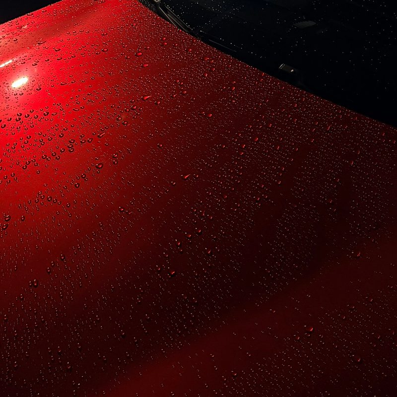 Water beading on glossy red paint