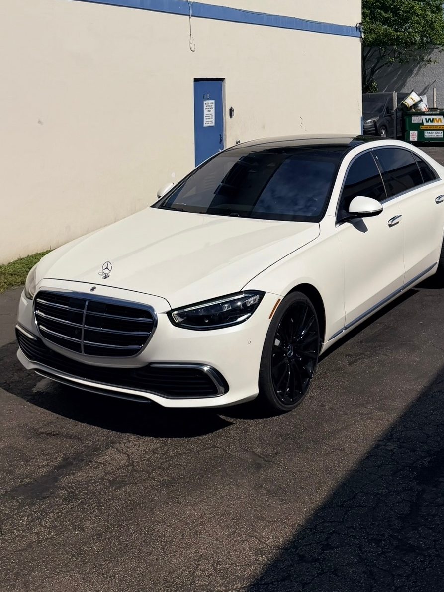 White Mercedes S-Class with dark-tinted windows