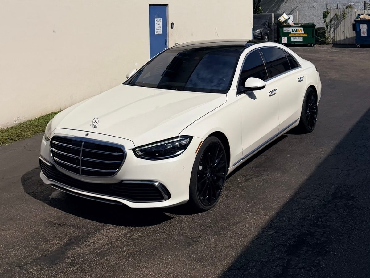 White Mercedes S-Class with dark-tinted windows